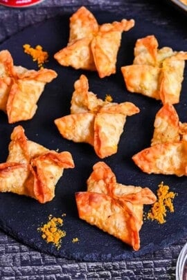 curry flavored age-gyoza (deep-fried gyoza) on a slate plate sprinkled with curry powder