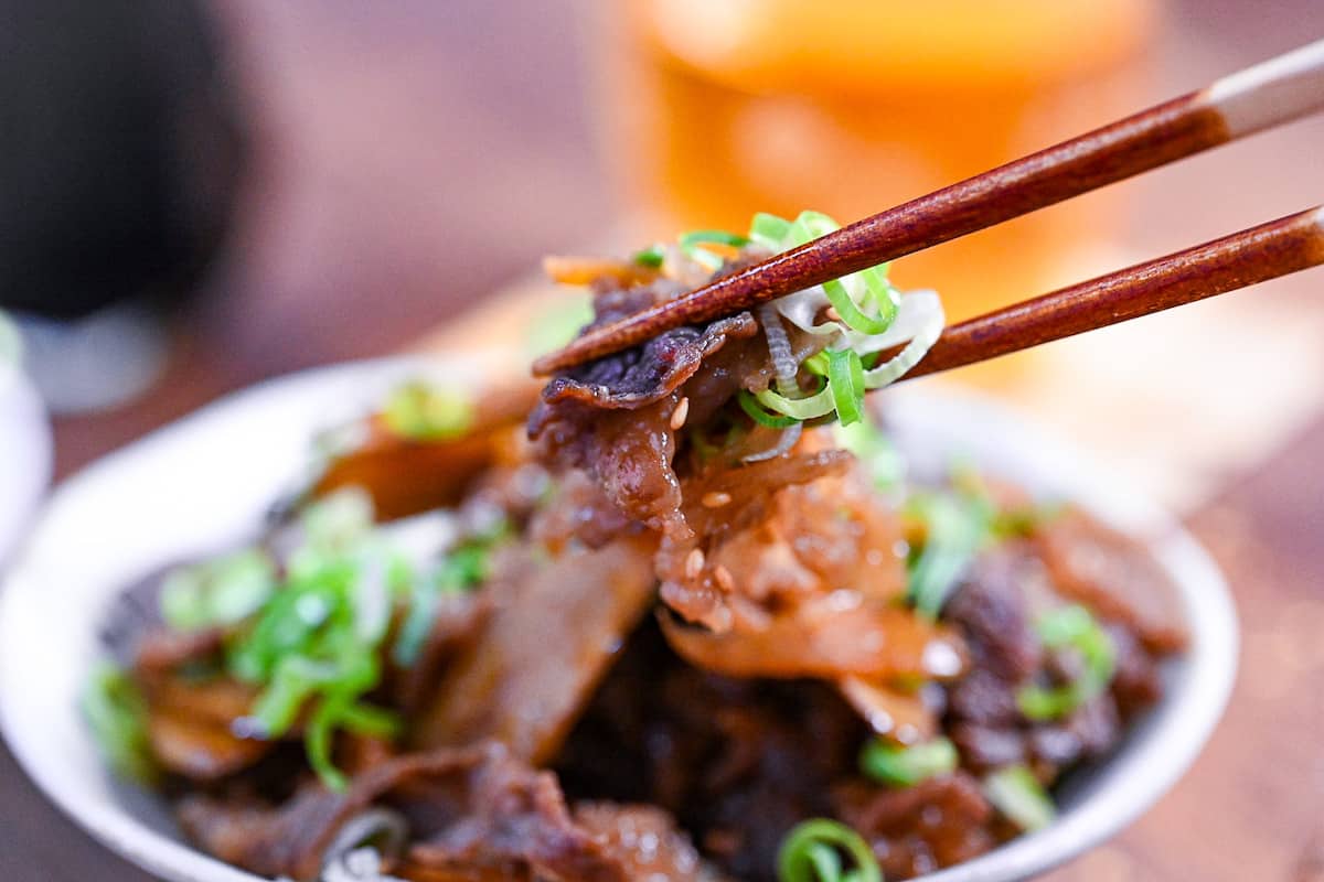 beef shigureni held with wooden chopsticks