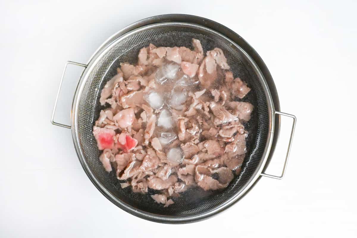 chilling blanched thinly sliced wagyu beef in ice cold water