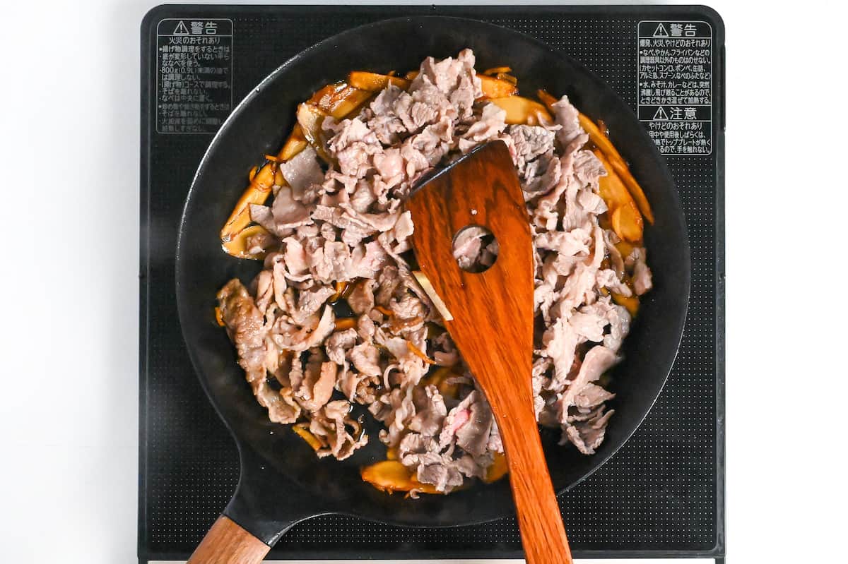 Adding blanched thinly sliced wagyu beef to frying pan to make shigureni
