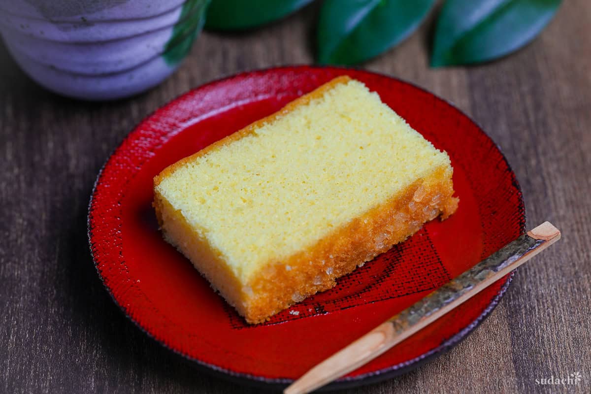 A slice of Japanese castella cake on a red plate