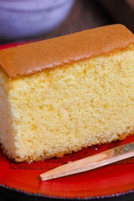 A piece of castella cake on a red plate