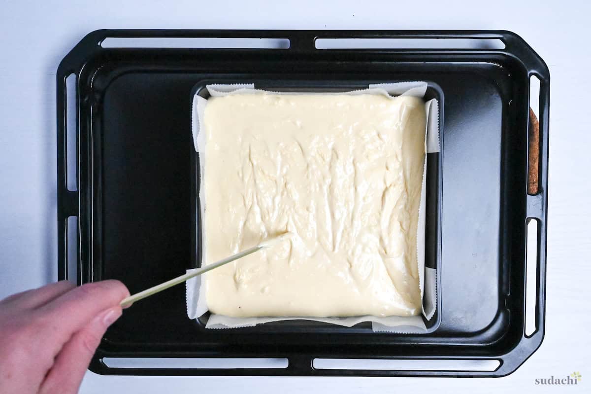drawing crosses across the surface of castella cake batter in a pan
