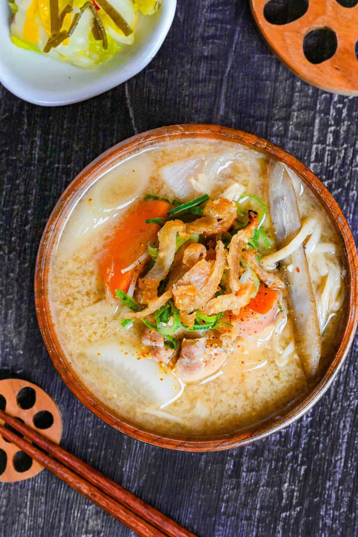 Japanese Chicken Miso Soup (Torijiru) in a wooden bowl topped with green onion and strips of crispy chicken skin