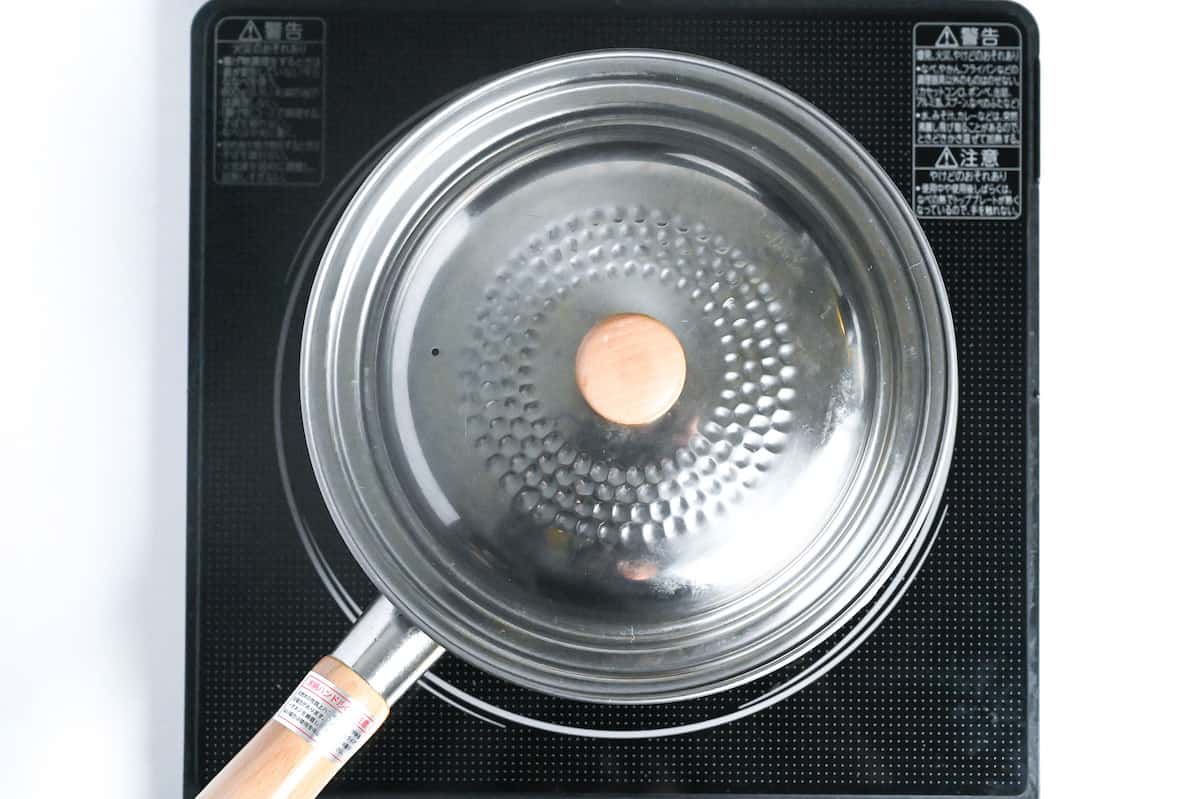 chicken miso soup simmering in a pot with lid