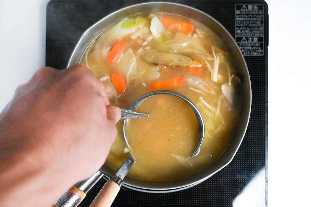 whisking miso paste into chicken miso soup