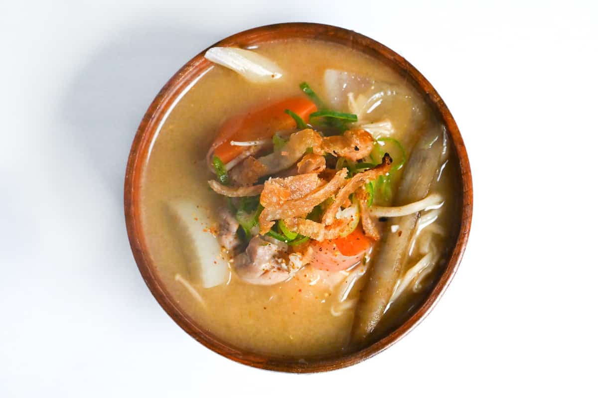 chicken miso in a wooden bowl topped with crispy chicken skin