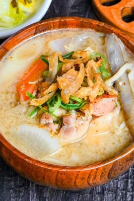Japanese Chicken Miso Soup (Torijiru) in a wooden bowl topped with green onion and strips of crispy chicken skin