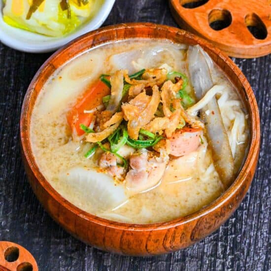 Japanese Chicken Miso Soup (Torijiru) in a wooden bowl topped with green onion and strips of crispy chicken skin