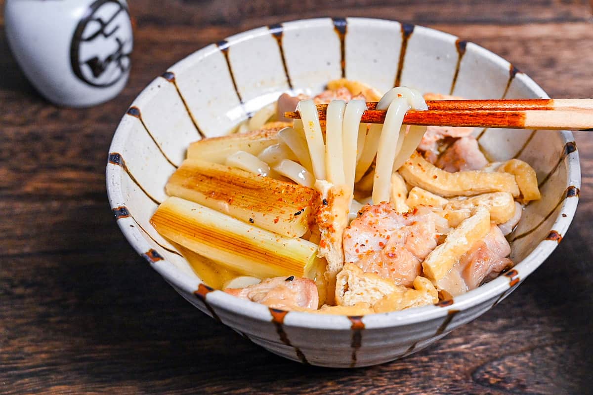 Chicken nanban udon with tofu and spring onion served in a striped bowl
