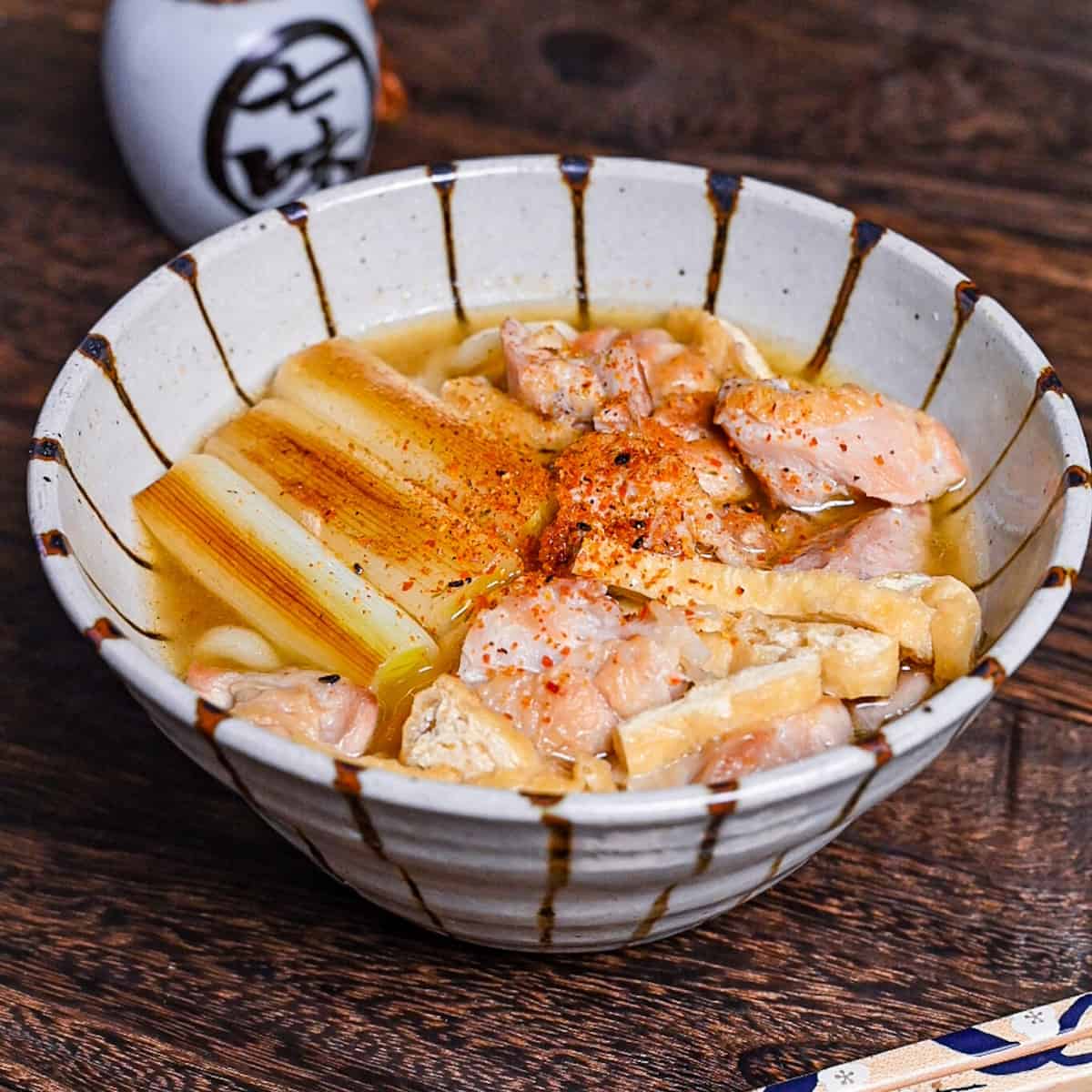 Chicken nanban udon with tofu and spring onion served in a striped bowl
