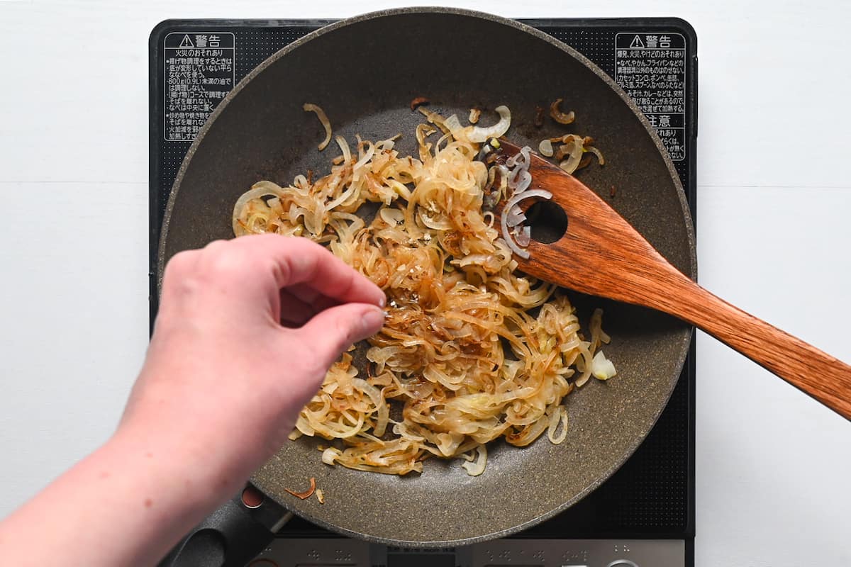 Softened onions in a pan sprinkled with salt