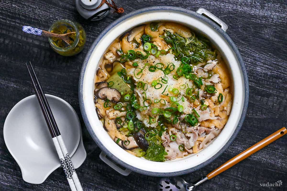 Daikon radish hot pot in a gray pot on a black wood-effect background top down