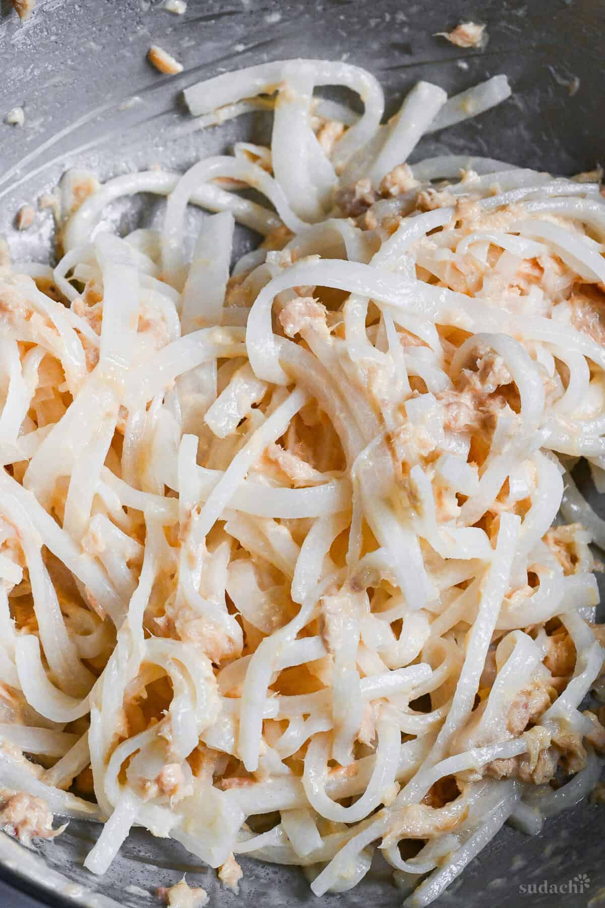 shredded daikon radish in a bowl coated with canned tuna and condiments