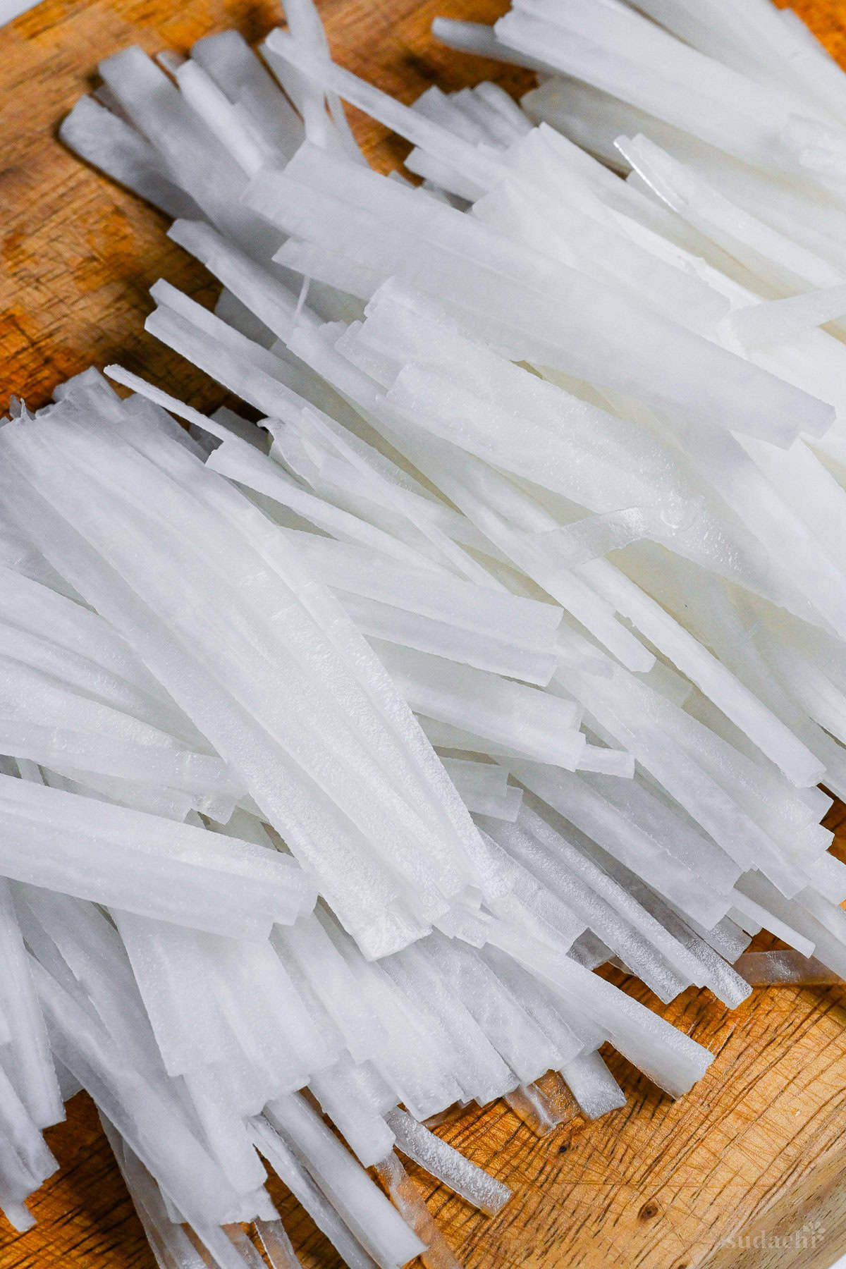 julienned daikon radish on a wooden chopping board