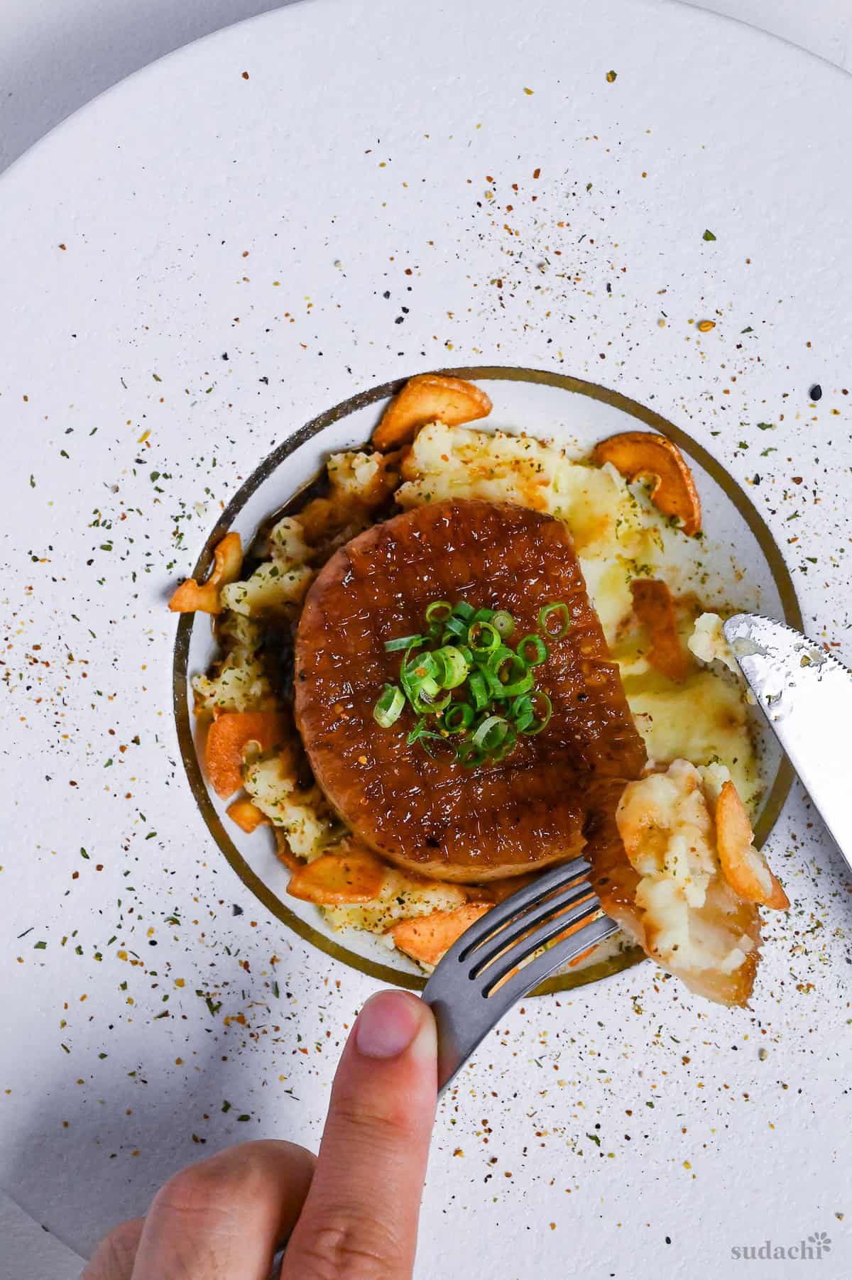 A cut daikon steak with a piece on a fork