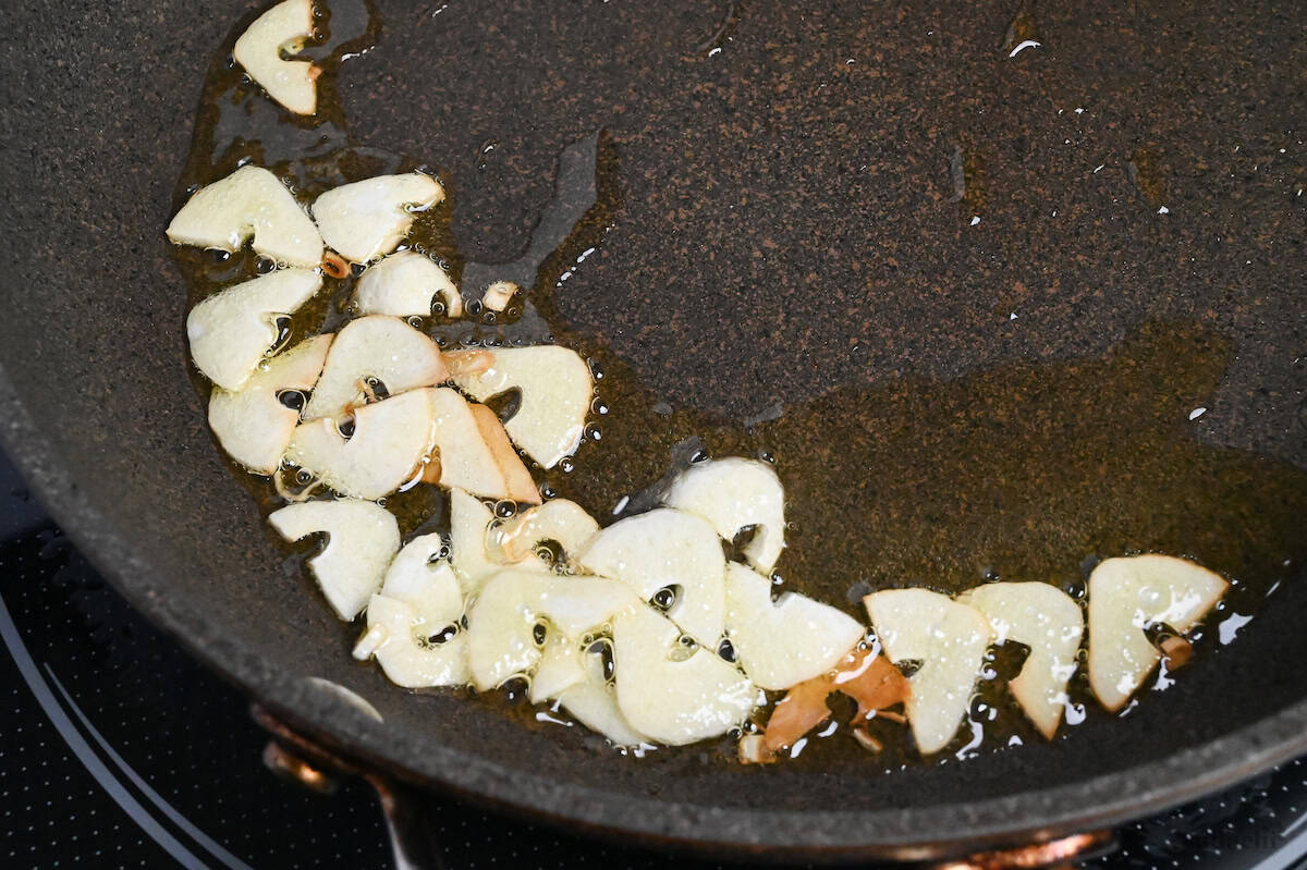 close up of garlic slices frying in oil