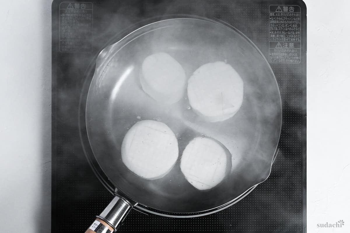 boiling daikon radish rounds in a pot of water on the stove