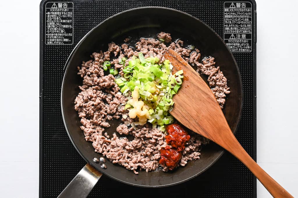 adding spring onion, ginger paste, garlic paste and tobanjan for tantanmen
