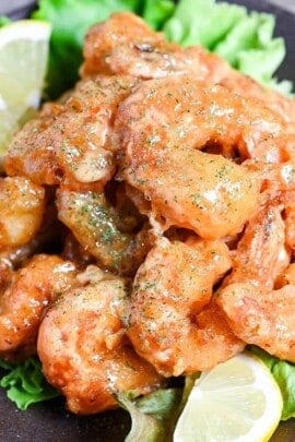 Ebi Mayo (Fried Shrimp in Mayonnaise Sauce) on a brown plate with salad and lemon wedges