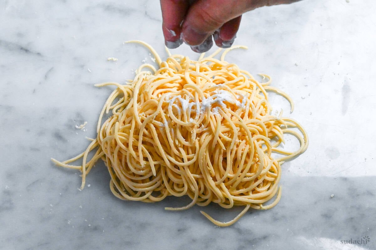 sprinkling homemade egg ramen noodles with starch