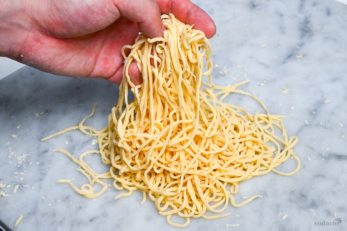 holding up homemade egg ramen noodles