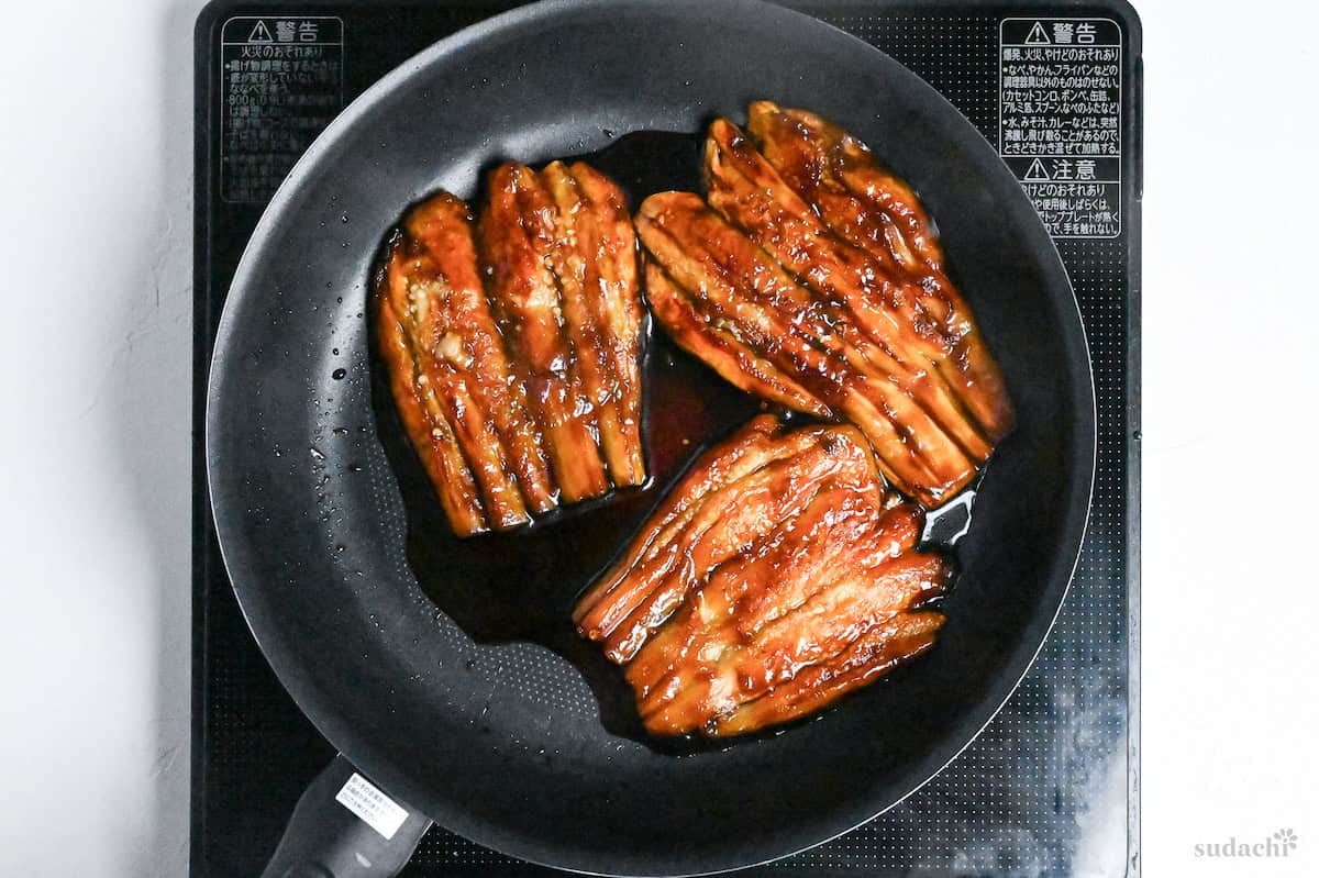 frying eggplant kabayaki with sauce in frying pan on the stove