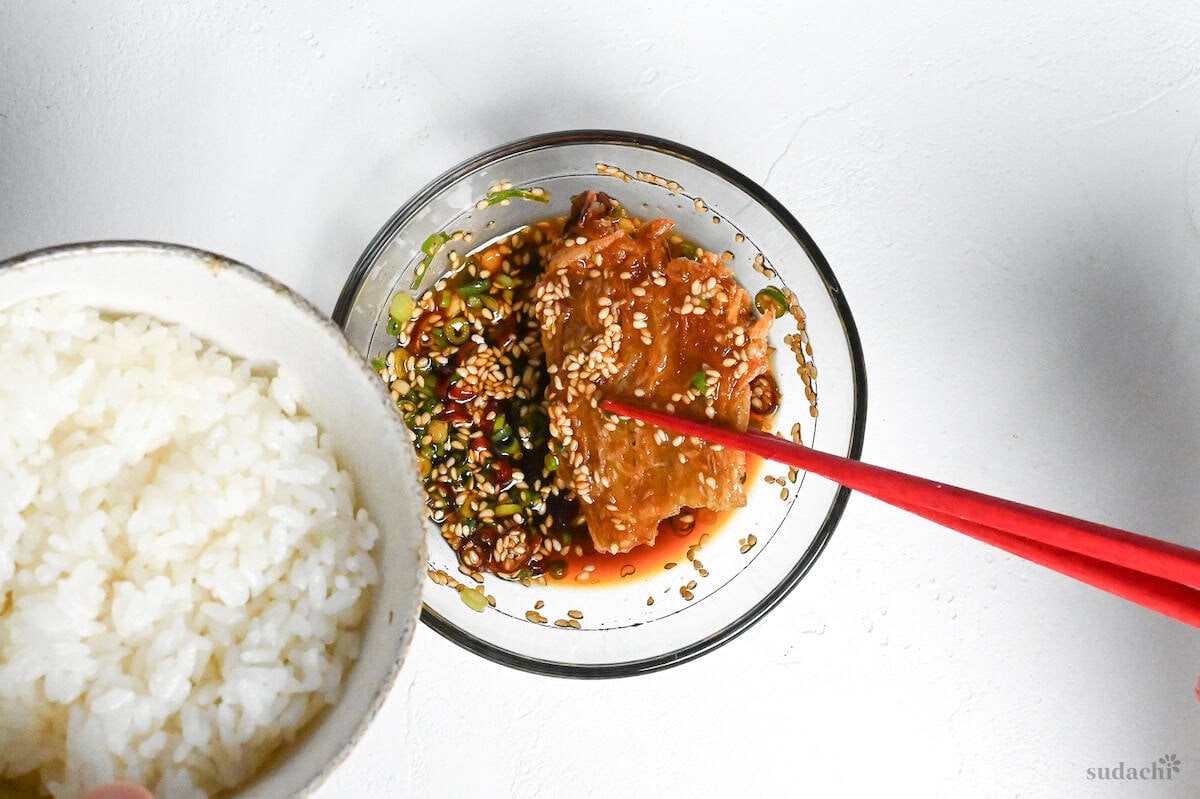 crispy enoki mushrooms dipped in sauce next to a bowl of plain rice