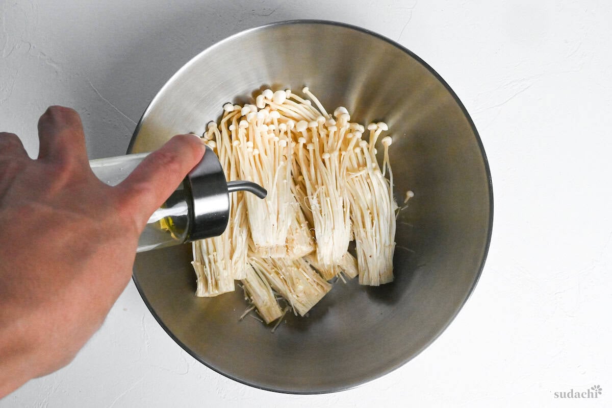 drizzling enoki mushrooms with oil