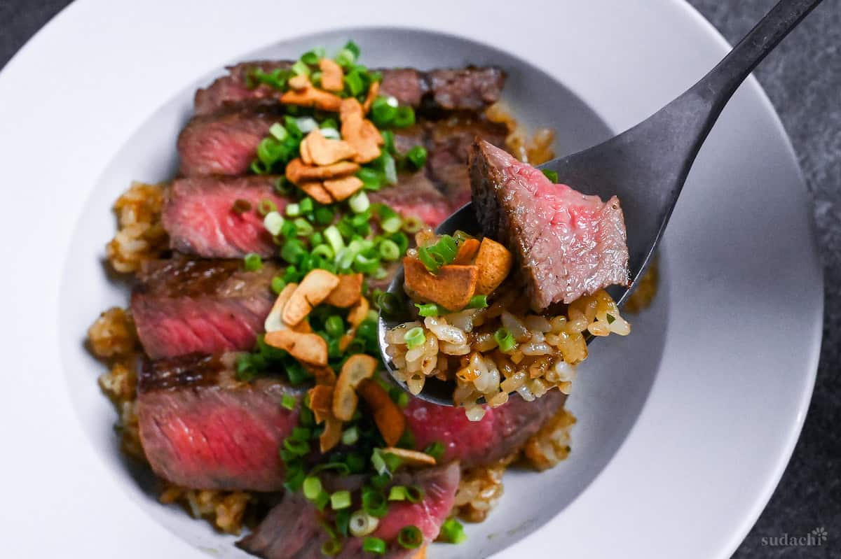 garlic fried rice and steak on a silver spoon