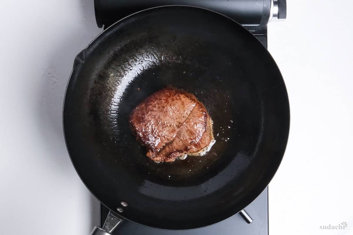 steak frying in a wok