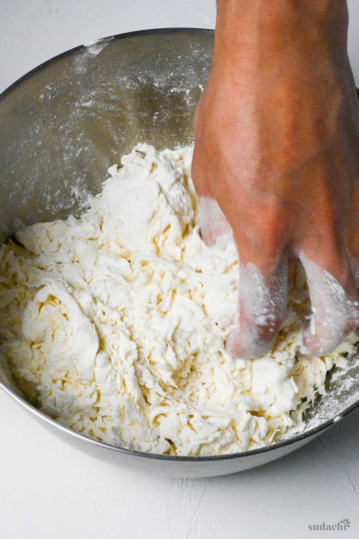 mixing ramen noodle dough in a steel mixing bowl