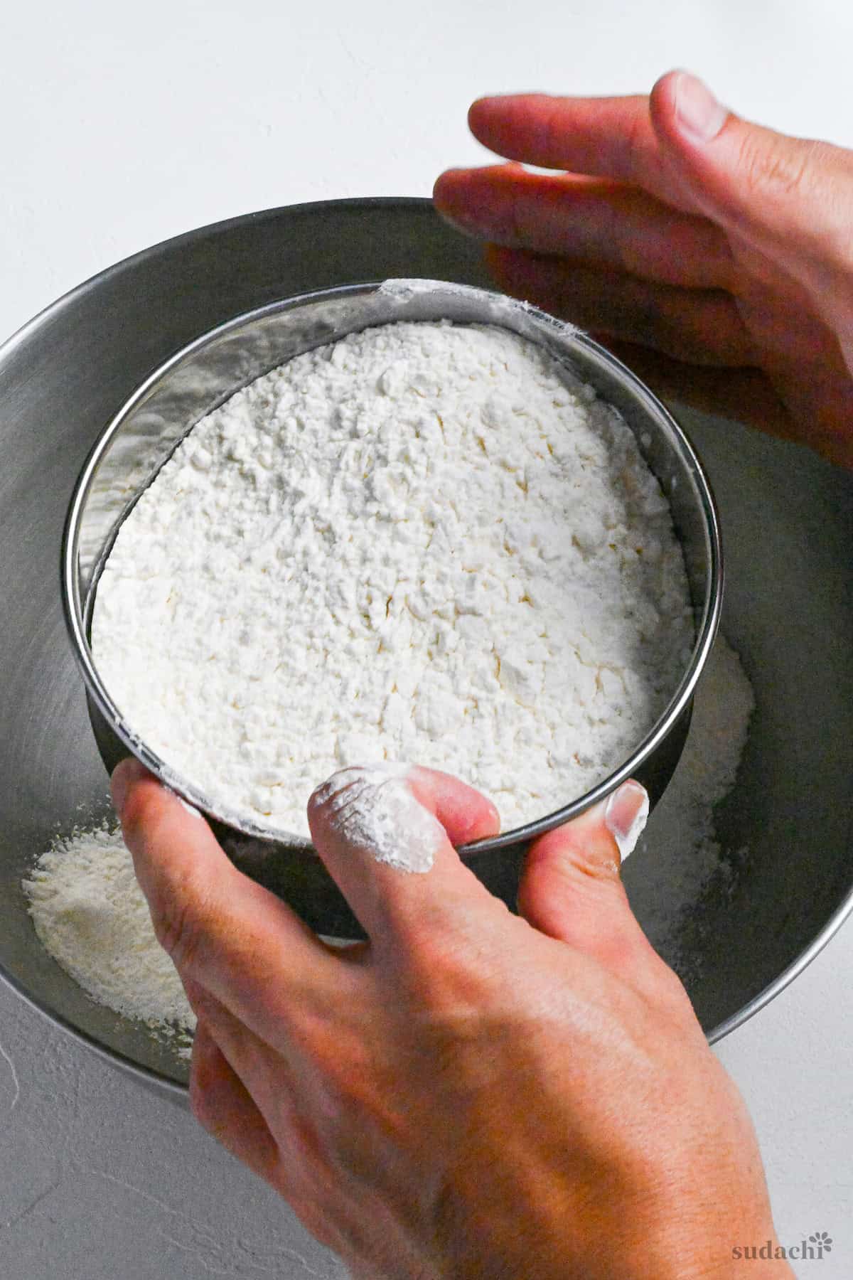 sifting flour to make homemade ramen noodles