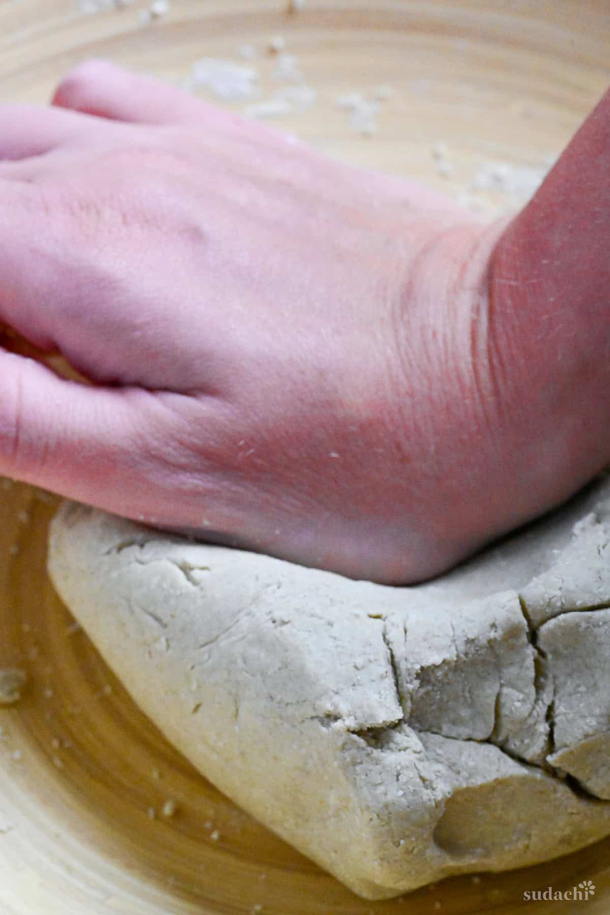 kneading soba noodle dough in a large wooden bowl