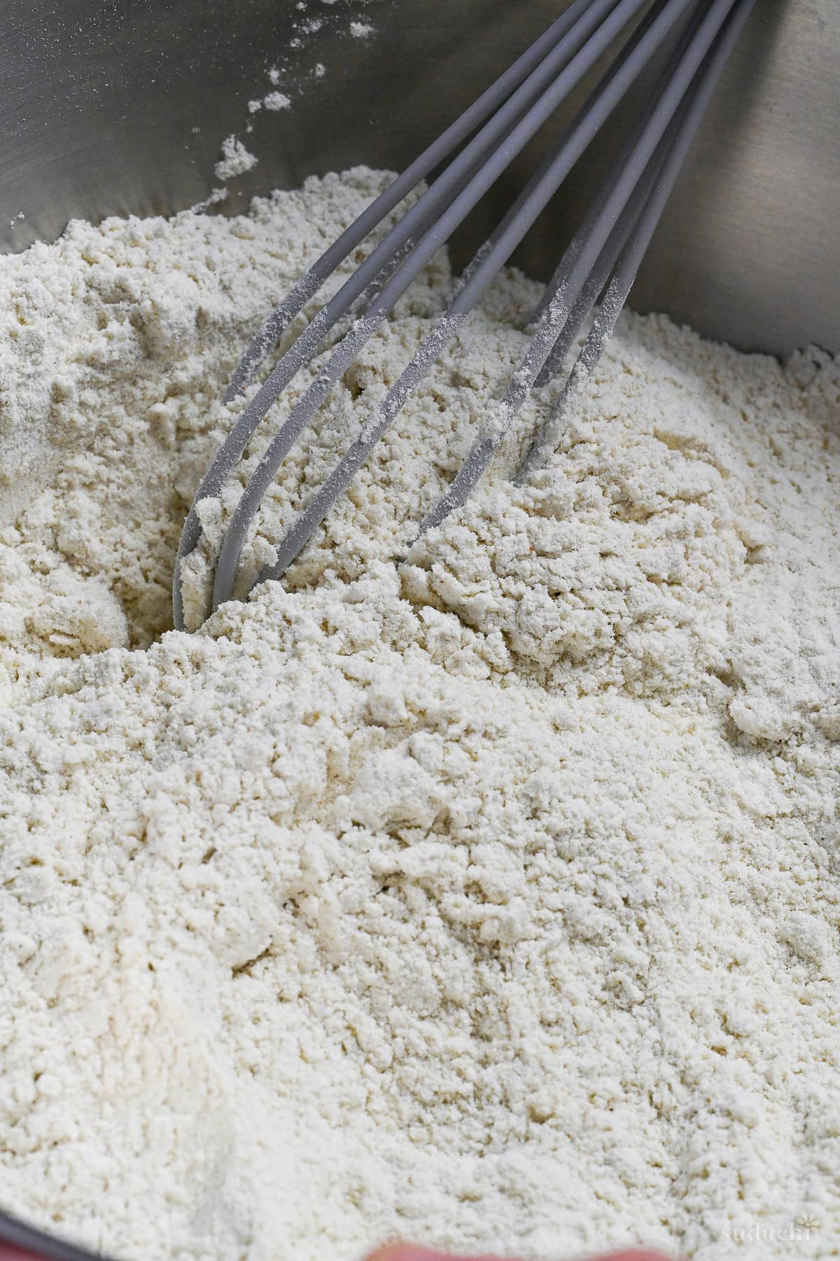 whisking soba flour and wheat flour together in a bowl