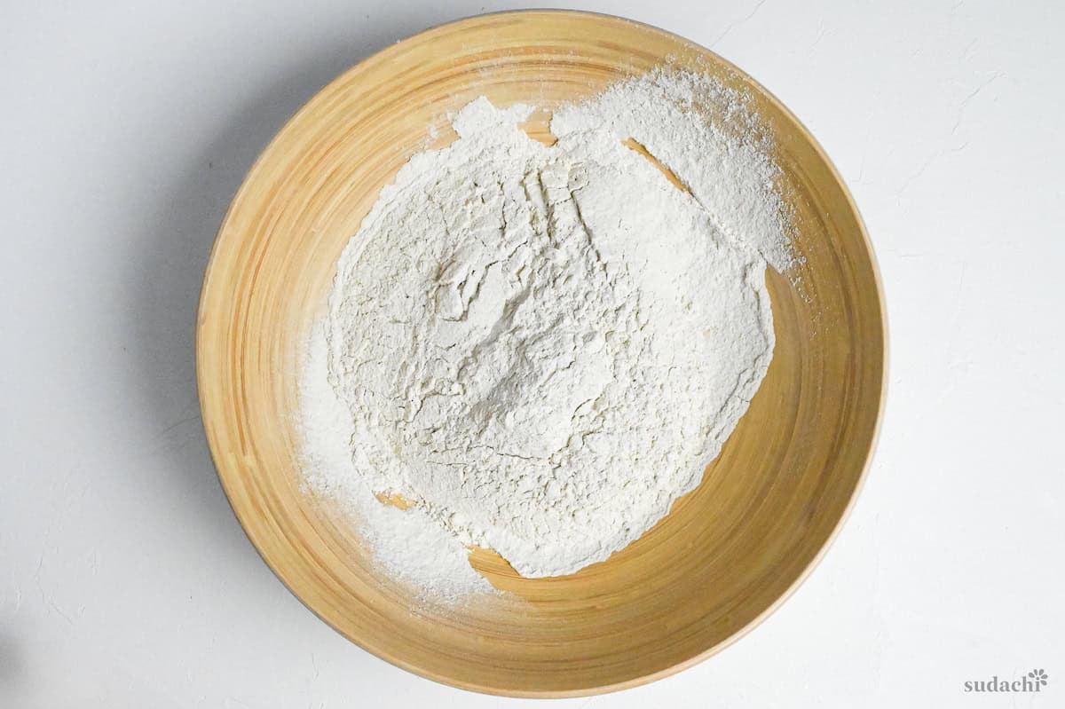 buckwheat flour and wheat flour mixture sifted into a large wooden bowl