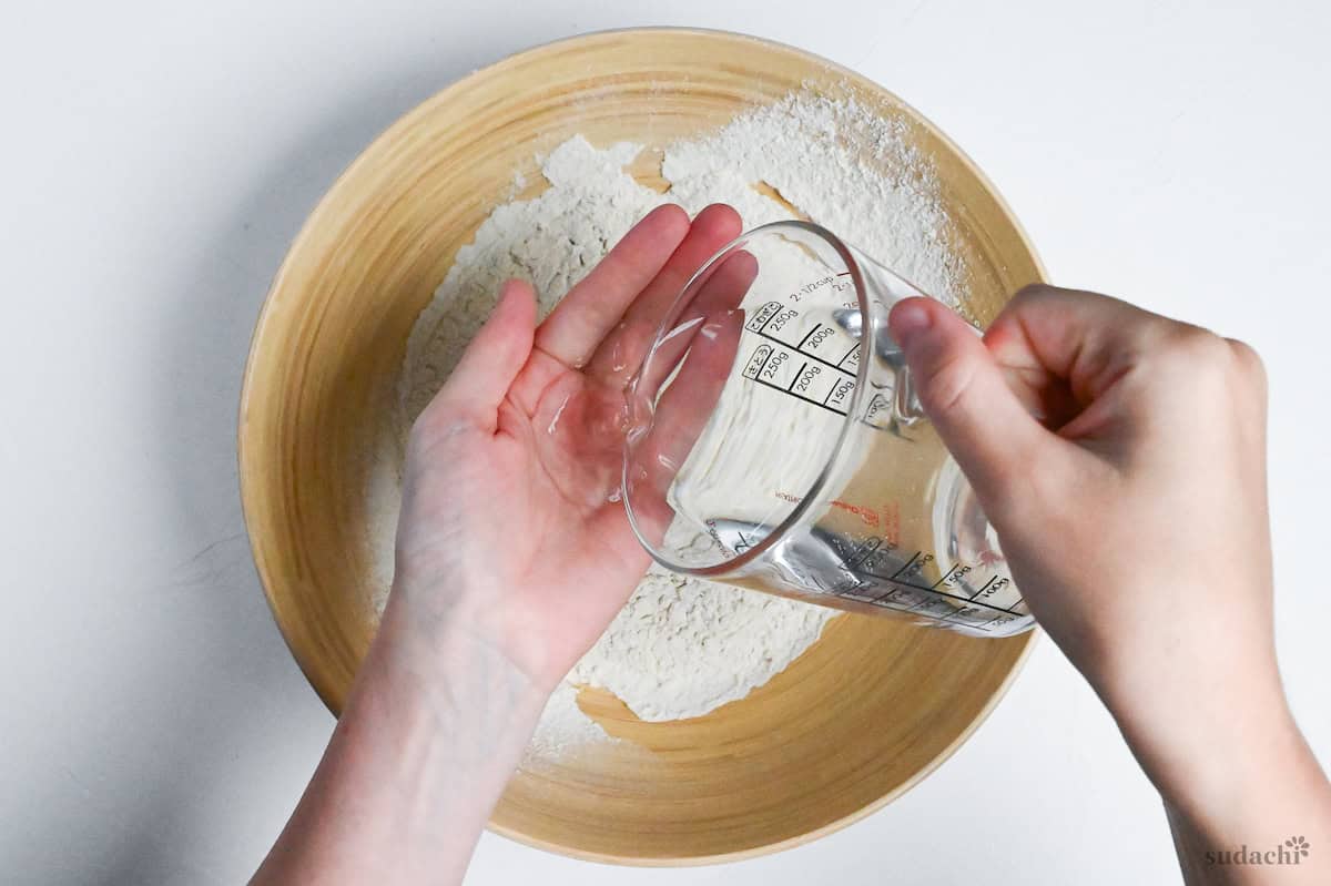 pouring water onto hands ready to make soba noodles