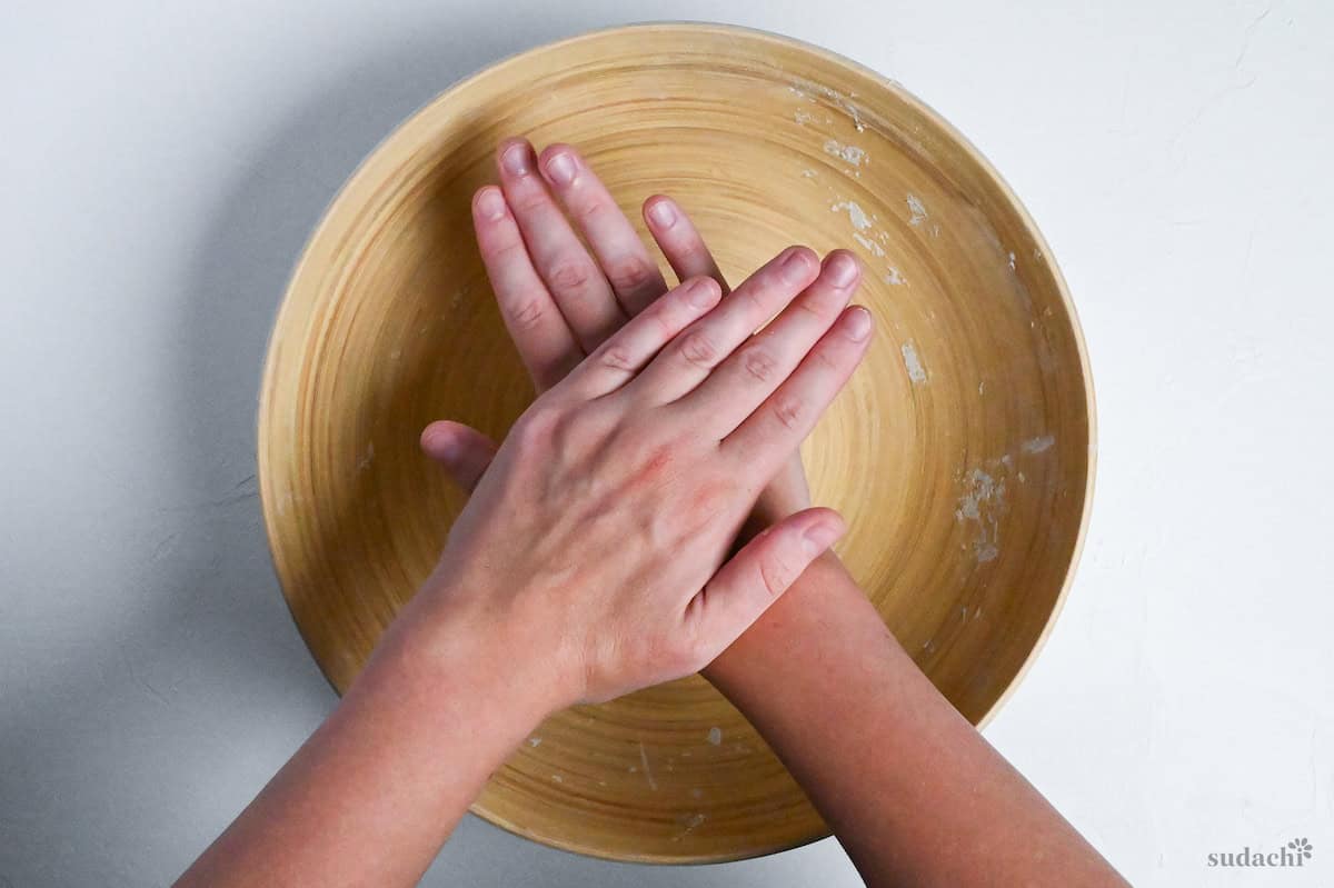 pressing soba noodle dough flat into a disc shape