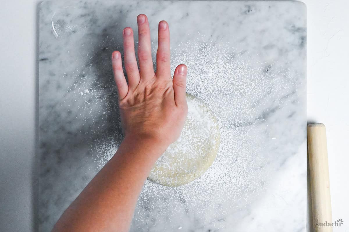spreading disc of soba noodle dough using palm