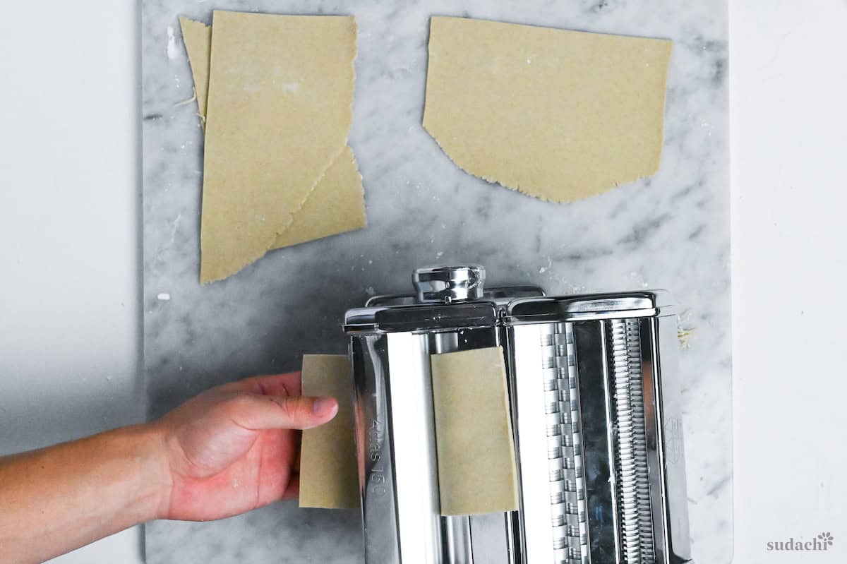 feeding soba noodle dough through a pasta machine