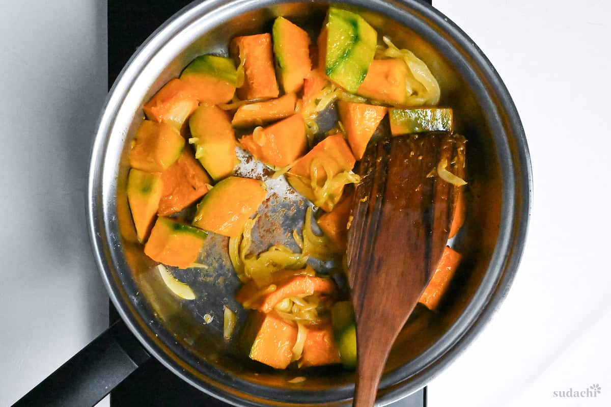 softened onion and kabocha in a stainless steel pan on the stove top