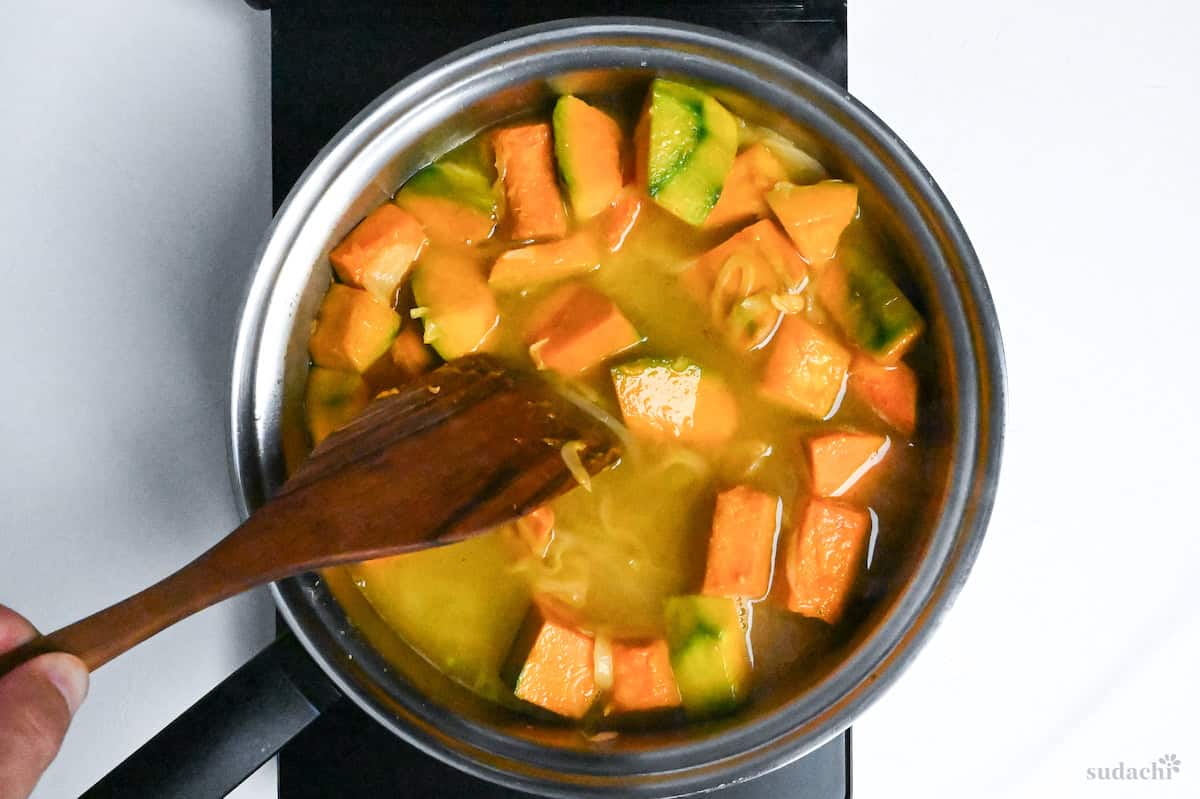 simmering kobocha and onion in kombu dashi in a pan