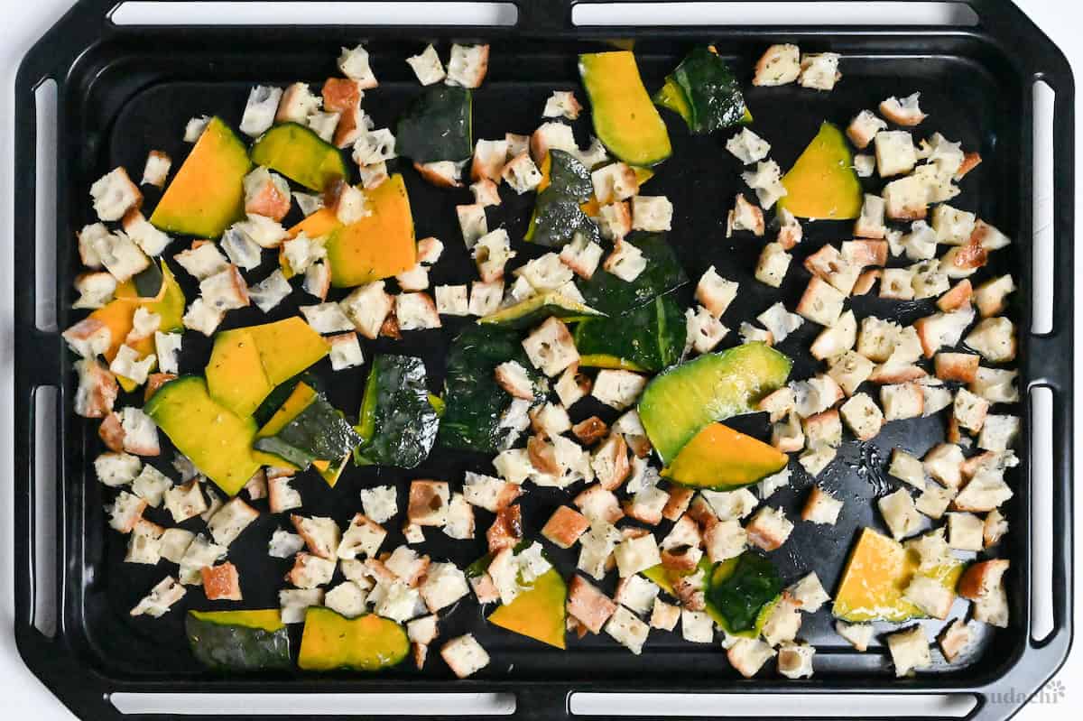 cubed baguette and kabocha in a single layer on a baking tray