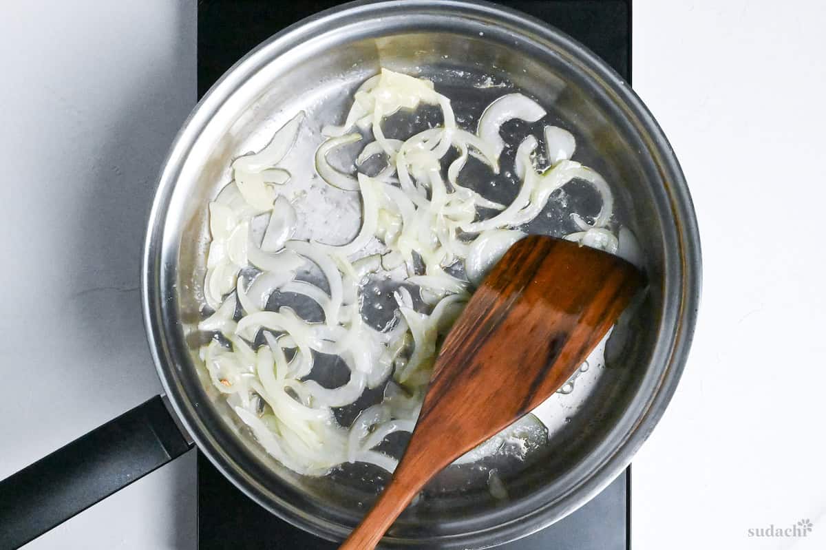 softened onion in a stainless steel pan