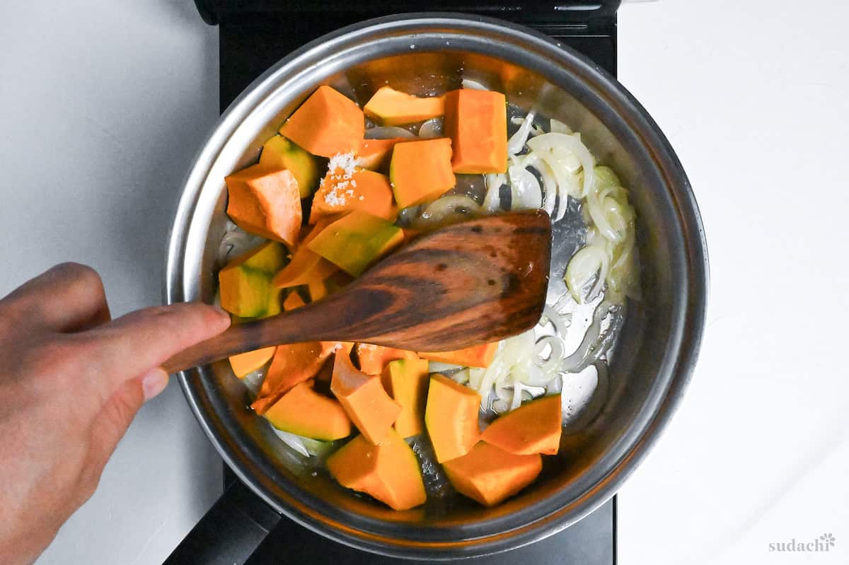 kabocha and onion in a stainless steel pan on the stove top