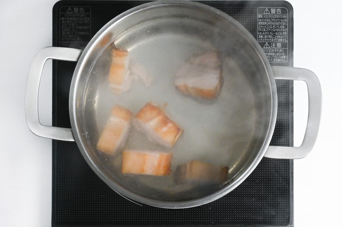 chunks of pork belly simmering in water