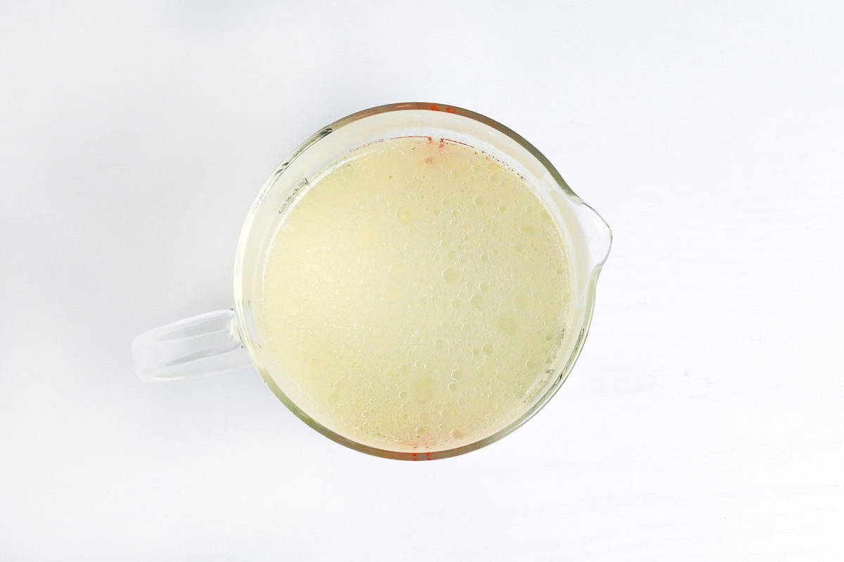 pork broth in a glass measuring jug