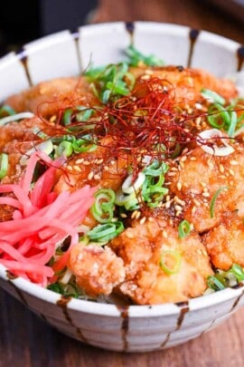 karaage don (Japanese fried chicken bowl) topped with sweet sauce, sesame seeds, chopped green onion, chili threads and pink pickled ginger.