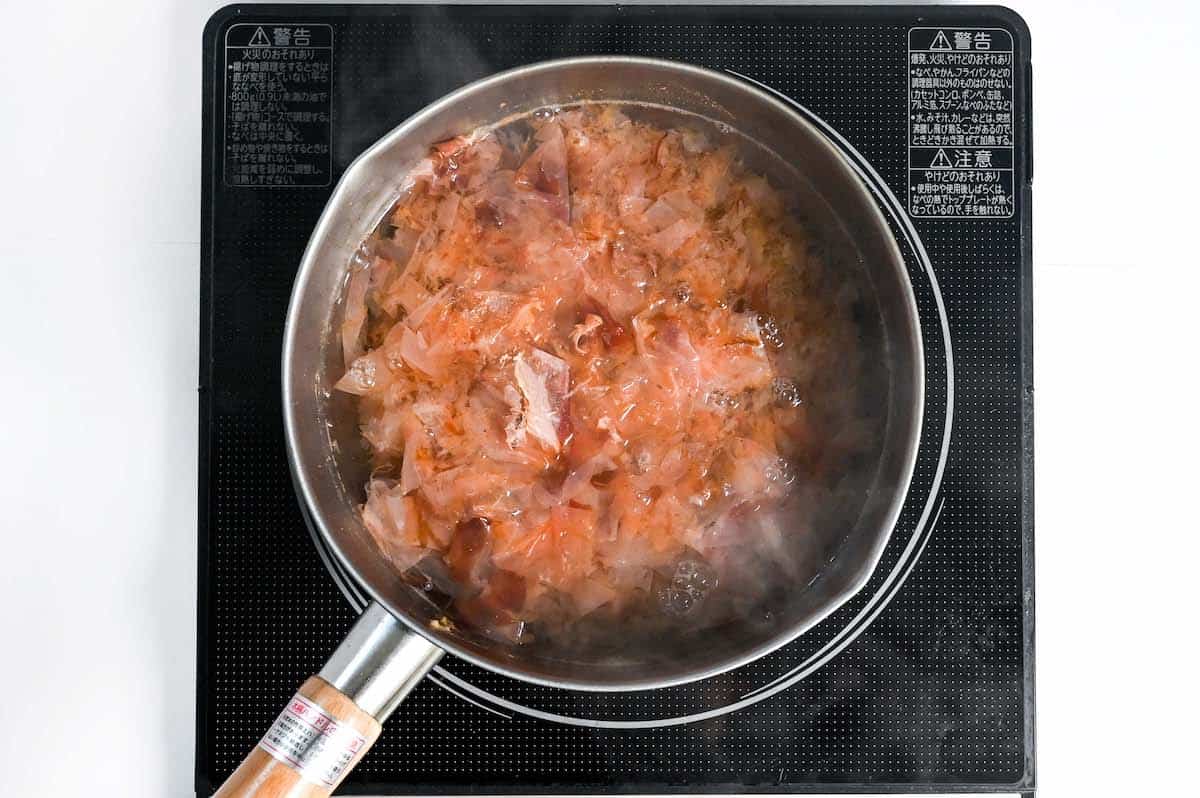 Adding fresh katsuobushi (bonito flakes) to a second batch of katsuo dashi