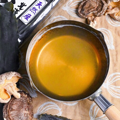 Vegan awase dashi made with kombu dried kelp and shiitake mushrooms in a steel pot